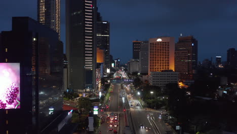 Low-flying-aerial-dolly-shot-of-cars-on-a-busy-multi-lane-road-in-Jakarta-city-center-at-night