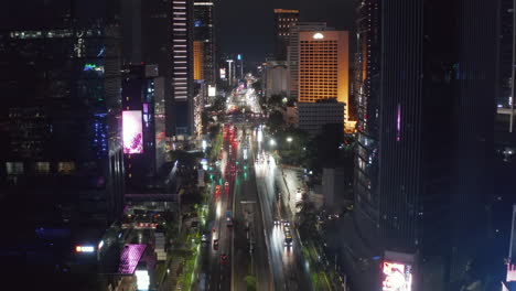 Aerial-descending-pedestal-shot-flying-sideways-of-busy-city-multi-lane-traffic-at-night-in-city-center-of-Jakarta