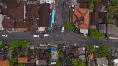 Top-down-overhead-aerial-view-timelapse-of-busy-rush-hour-traffic-at-the-intersection-in-Canggu,-Bali.-Typical-busy-car-and-motorcycle-traffic-at-urban-crossroads-on-the-streets-of-Bali,-Time-Lapse
