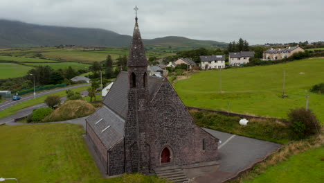 Aerial-ascending-footage-of-historic-structure-of-stone-church-of-St-John-the-Baptist.-Old-religious-landmark-with-tower.-Ireland