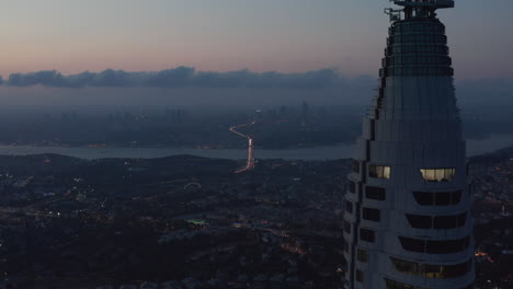 Huge-Skyscraper-Istanbul-TV-Tower-on-Hill-with-epic-view-over-all-of-Istanbul,-Turkey-at-Dusk,-Aerial-Drone-Shot