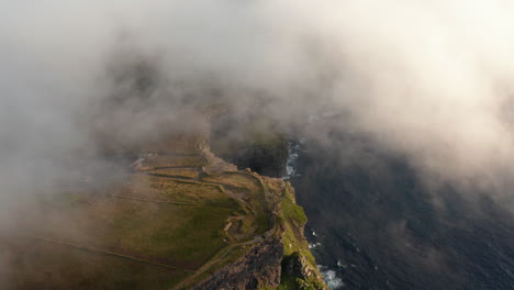 Luftaufnahmen-Von-Küstenklippen,-Die-In-Tiefe-Wolken-Gehüllt-Sind.-Malerische-Landschaft-Der-Goldenen-Stunde.-Klippen-Von-Moher,-Irland