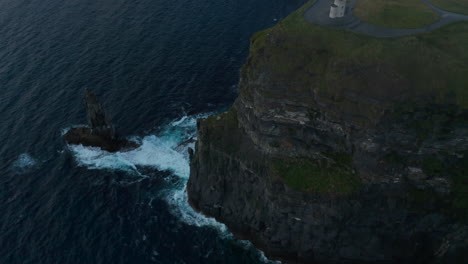High-angle-view-of-waves-crashing-on-rocky-sea-coast.-High-cliffs-and-viewing-point-on-top.-Cliffs-of-Moher,-Ireland