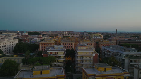 Forwards-fly-above-buildings-in-urban-borough.-Apartment-buildings-in-housing-estate-in-large-city-at-twilight.-Rome,-Italy