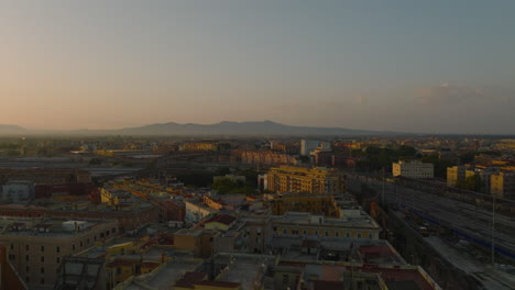 Aerial-panoramic-footage-of-apartment-buildings-in-urban-borough-lit-by-bright-morning-sun.-Rome,-Italy