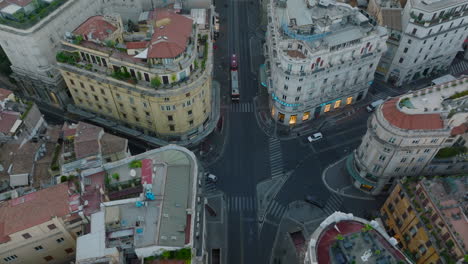 High-angle-view-of-road-intersection-surrounded-by-luxury-palaces-in-city-centre.-Aerial-descending-footage-of-buildings-with-rooftop-terraces.-Rome,-Italy