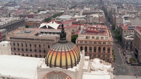 Drone-camera-flying-around-colorful-dome-with-bird-sculpture-of-Palace-of-fine-arts-(Palacio-de-Bellas-Artes)-in-historic-city-center.-Mexico-city,-Mexico.