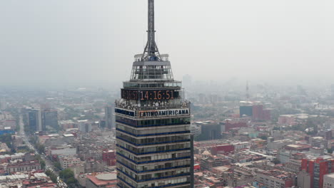Aerial-drone-view-of-Torre-Latinoamericana-tall-building.-Camera-flying-around-top-of-skyscraper,-cityscape-in-background.-Mexico-city,-Mexico.