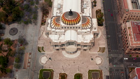Forwards-fly-aerial-shot-of-Palace-of-fine-arts-(Palacio-de-Bellas-Artes)-with-colourful-dome-in-historic-part-of-city.-Mexico-City,-Mexico.
