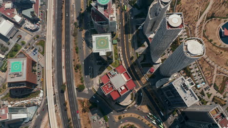 Aerial-birds-eye-overhead-top-down-view-of-multilane-road-leading-along-group-of-tall-buildings-in-Santa-Fe.-Tilt-down-shot.-Mexico-City,-Mexico.