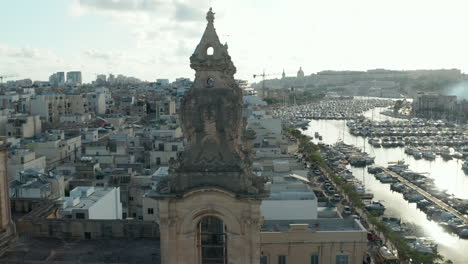 Nahaufnahme-Von-Zwei-Kirchtürmen-Auf-Malta-Mit-Segelbooten-Und-Yachthafen-Im-Hintergrund-An-Einem-Schönen-Sonnigen-Tag,-Luftrutsche-Links