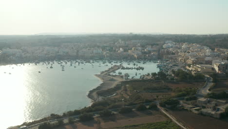 Bahía-Llena-De-Veleros-Y-Yates-A-La-Luz-Del-Atardecer-En-La-Isla-De-Malta,-Muñeca-Aérea-Hacia-Adelante