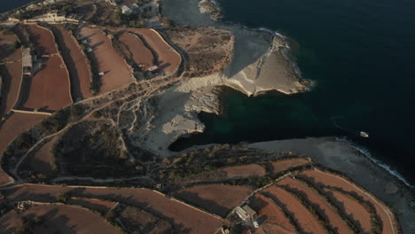 Famoso-Lugar-Turístico-De-La-Piscina-De-San-Pedro-En-La-Isla-De-Malta-Con-Turismo-A-La-Luz-Del-Atardecer-De-Verano,-Amplia-Vista-Aérea