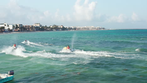 Couples-finishing-their-jet-ski-ride-and-cruising-back-to-the-beach.-Aerial-view-with-watercrafts-on-the-Caribbean-Sea