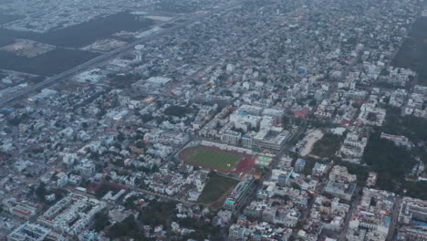 Football-stadium-in-the-middle-of-the-city-in-Playa-del-Carmen,-Mexico.-Aerial-view,-zoom-in