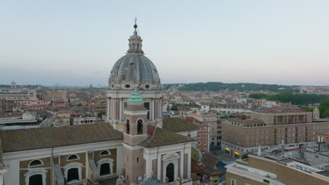 Elevated-slide-and-pan-shot-of-large-cupola-of-San-Carlo-al-Corso-basilica.-Town-development-in-city-centre-in-background.-Rome,-Italy