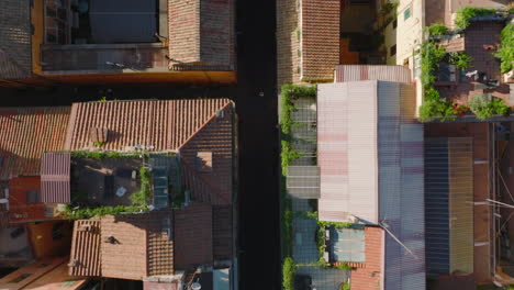 Fly-above-residential-houses-in-urban-borough.-Top-down-panning-footage-of-narrow-streets-and-buildings-with-balconies-and-terraces.-Rome,-Italy