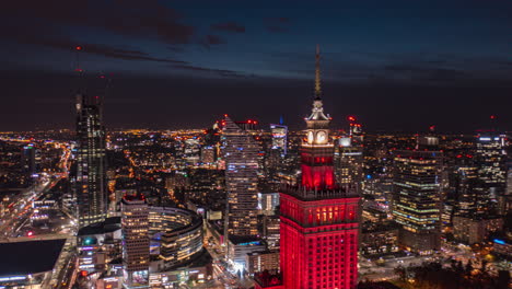 Slide-and-pan-footage-of-night-cityscape.-Hyperlapse-shot-of-red-illuminated-historic-high-rise-Palace-of-Culture-and-Science.-Warsaw,-Poland