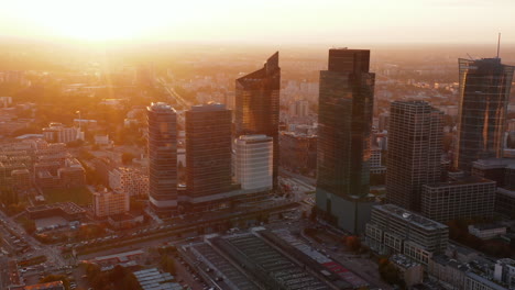 Group-of-downtown-skyscrapers-against-rising-sun.-Tall-modern-office-or-apartment-buildings.-Warsaw,-Poland