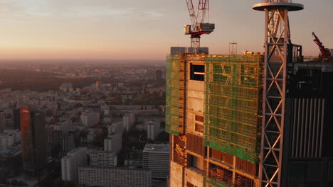 Elevated-view-of-city-from-top-of-high-rise-building-construction-site-in-sunset-time.-Warsaw,-Poland
