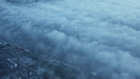 Amazing-aerial-footage-of-Swietokrzyski-Bridge-shrouded-in-fog.-Tall-concrete-pillar-with-supporting-cables-protruding-above-white-mist.-Warsaw,-Poland