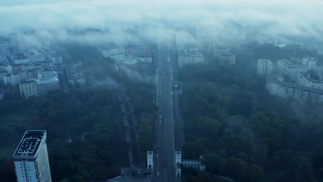 High-angle-view-of-wide-street-and-railway-track-leading-through-town.-Morning-shot-through-sparse-fog-or-low-clouds.-Warsaw,-Poland