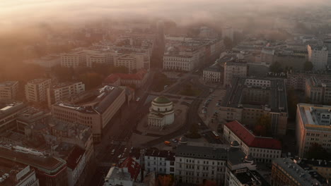 Aerial-footage-of-traffic-on-road-around-church-at-Three-Crosses-Square.-Morning-shot-of-buildings-in-central-town-district.-Warsaw,-Poland