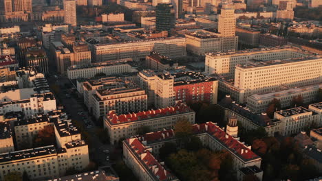 Slide-and-pan-shot-of-large-apartment-or-administrative-buildings-in-town-illuminated-by-bright-rising-sun.-Warsaw,-Poland