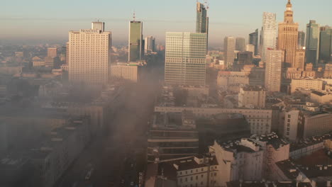 Descending-forwards-fly-above-morning-city.-Revealing-high-rise-buildings-lit-by-bright-rising-sun.-Warsaw,-Poland