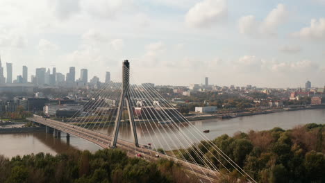 Amazing-modern-transport-construction,-tall-cable-stayed-Swietokrzyski-Bridge-over-Vistula-river.-Cityscape-in-background.-Warsaw,-Poland