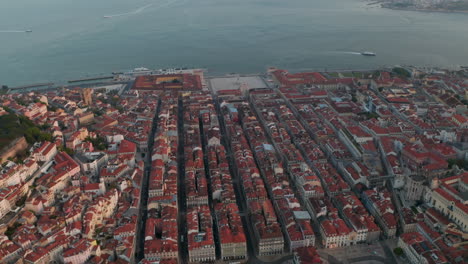 Slow-rotating-aerial-view-of-coastal-colorful-houses-and-famous-landmarks-in-city-center-of-Lisbon,-Portugal