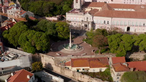 Aerial-dolly-in-view-of-Chafariz-das-Necessidades-water-fountain-by-the-church-in-urban-city-center-of-Lisbon,-Portugal