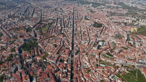 High-angle-view-of-rooftops-cityscape.-Long-straight-street-from-slowly-forward-flying-drone.-Lisbon,-capital-of-Portugal.
