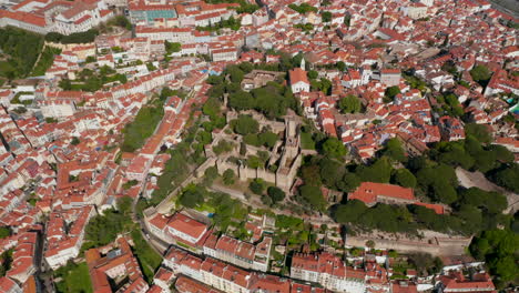 Aerial-view-medieval-stone-Saint-George-Castle-on-hill-above-town.-Drone-camera-flying-around-castle-hill.-Lisbon,-capital-of-Portugal.