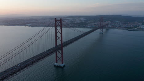 Luftdrohne-Abendansicht-Der-Brücke-Vom-25.-April-über-Den-Fluss-Tegus.-Silhouette-Einer-Langen-Schrägseilbrücke.-Lissabon,-Hauptstadt-Von-Portugal.