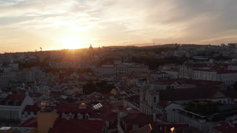 Slider-aerial-view-of-rooftops-of-colorful-old-European-houses-in-urban-city-center-of-Lisbon,-Portugal-during-sunset