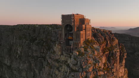 Fly-around-upper-cable-car-station-on-Table-Mountain-summit.-Transport-tourists-up-on-famous-nature-landmark.-Cape-Town,-South-Africa
