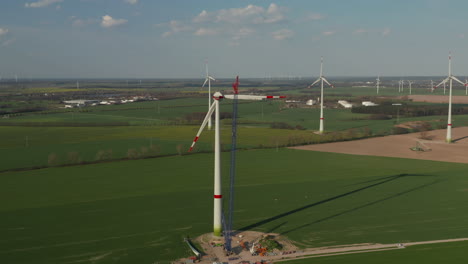 Assembling-of-huge-propeller-of-wind-power-station.--Green-energy,-ecology-and-carbon-footprint-reduction-concept