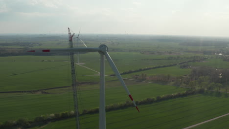 Aerial-view-of-wind-turbine-construction.-Rotor-with-missing-one-blade.-Green-energy,-ecology-and-carbon-footprint-reduction-concept
