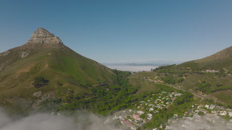 Aufsteigende-Luftaufnahmen-Von-Bergen,-Die-Aus-Nebel-Aufsteigen.-Lions-Head-Mountain-Und-Umliegender-Straßenpass.-Kapstadt,-Süd-Afrika