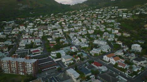 High-angle-view-of-apartment-houses-and-pensions.-Tilt-up-reveal-of-mountains-in-background.-Cape-Town,-South-Africa
