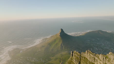 Aerial-panoramic-footage-of-mountains-around-town.-Rugged-sharp-rock-ridge-on-Table-mountain-and-famous-Lions-Head-mountain-on-ocean-coast.-Cape-Town,-South-Africa