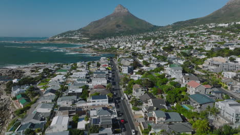 Fly-above-streets-surrounded-by-residential-and-vacation-properties.-Suburb-on-seaside-and-mountain-peak-with-steep-slopes-in-background.-Cape-Town,-South-Africa