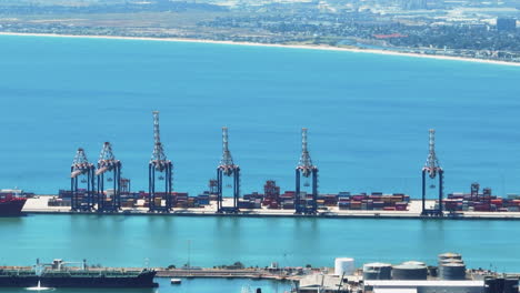 Große-Kräne-Und-Gestapelte-überseecontainer-Im-Hafen-Und-Auf-Der-Blauen-Wasseroberfläche.-Transport--Und-Logistikkonzept.-Kapstadt,-Süd-Afrika