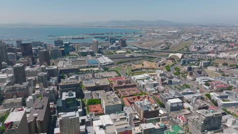 Aerial-panoramic-footage-of-city-with-harbour-in-distance.-Backwards-reveal-of-multistorey-buildings.-Cape-Town,-South-Africa