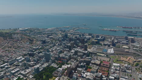 High-angle-view-of-city-on-sea-coast.-Tall-buildings-in-city-centre,-train-station-and-harbour.-Cape-Town,-South-Africa