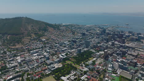 Aerial-panoramic-footage-of-city-on-sea-coast.-Various-buildings-in-town-district-and-hill-above.-Cape-Town,-South-Africa