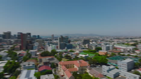 Toma-Panorámica-Del-Desarrollo-En-La-Ciudad.-Barrio-Residencial-Bajo-Ladera-De-Cerro-Y-Barrio-Comercial-Con-Altos-Edificios-De-Oficinas.-Ciudad-Del-Cabo,-Sudáfrica