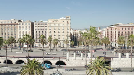 Elevated-static-shot-of-traffic-on-roads-and-pedestrian-zone-with-palm-trees-in-city.-Barcelona,-Spain