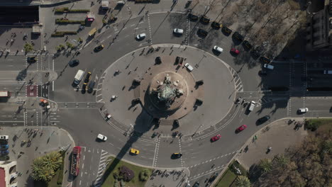 Birds-eye-shot-of-traffic-on-multilane-roundabout-around-Columbus-Monument.-Oval-round-intersection-in-city.-Barcelona,-Spain